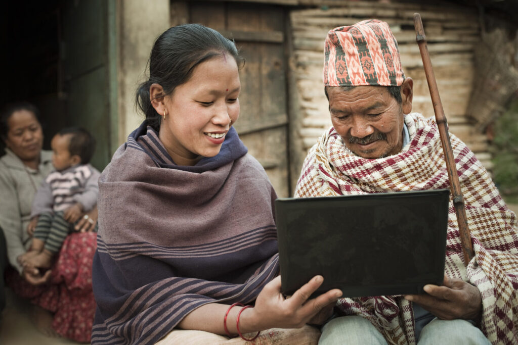 Woman and man looking at laptop in Nepal.